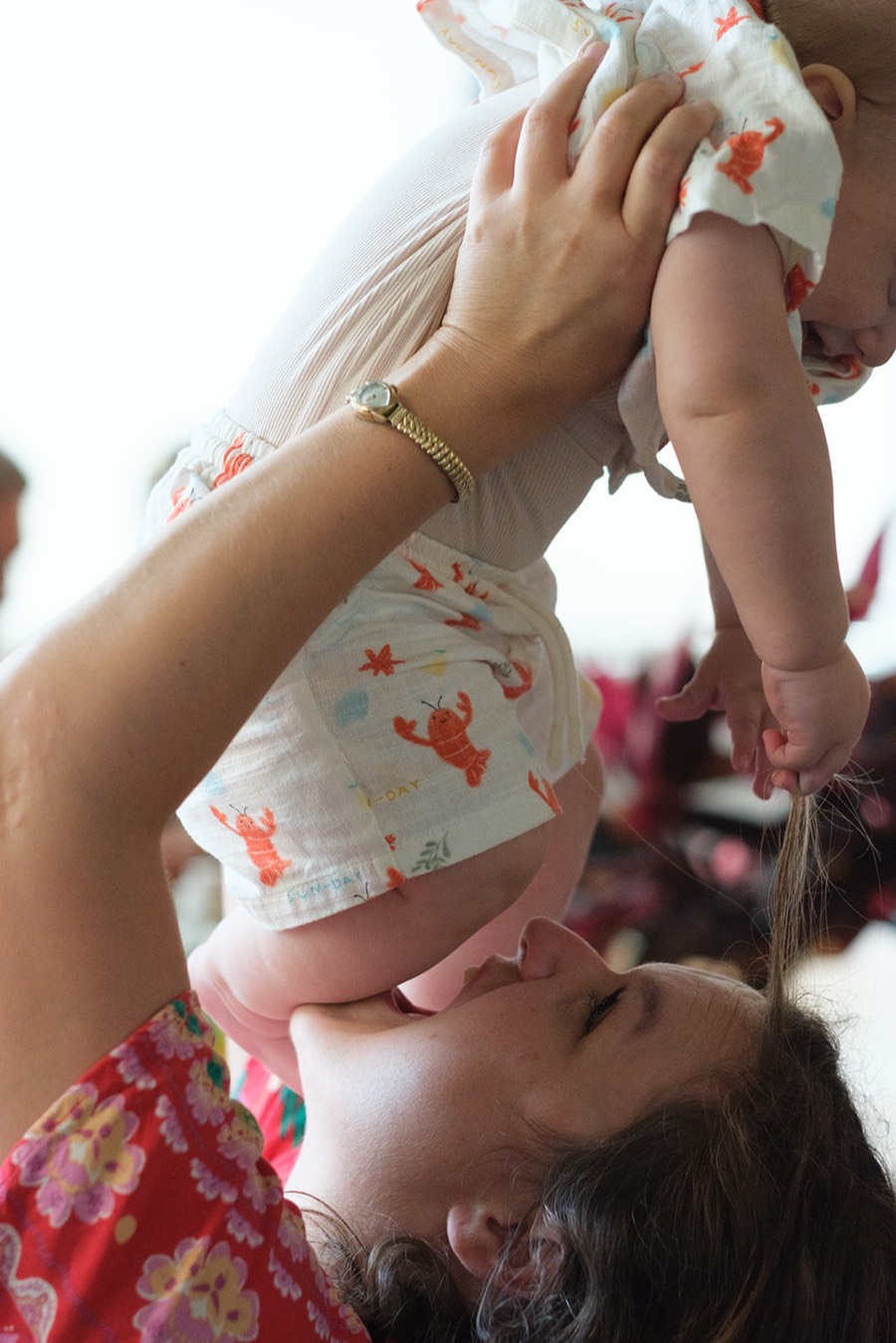 A mum lifting her baby up for a kiss at the pilot