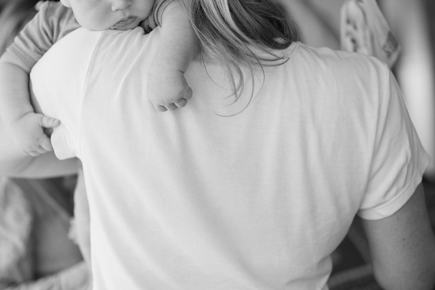A baby resting their head on their mum's shoulder at the pilot