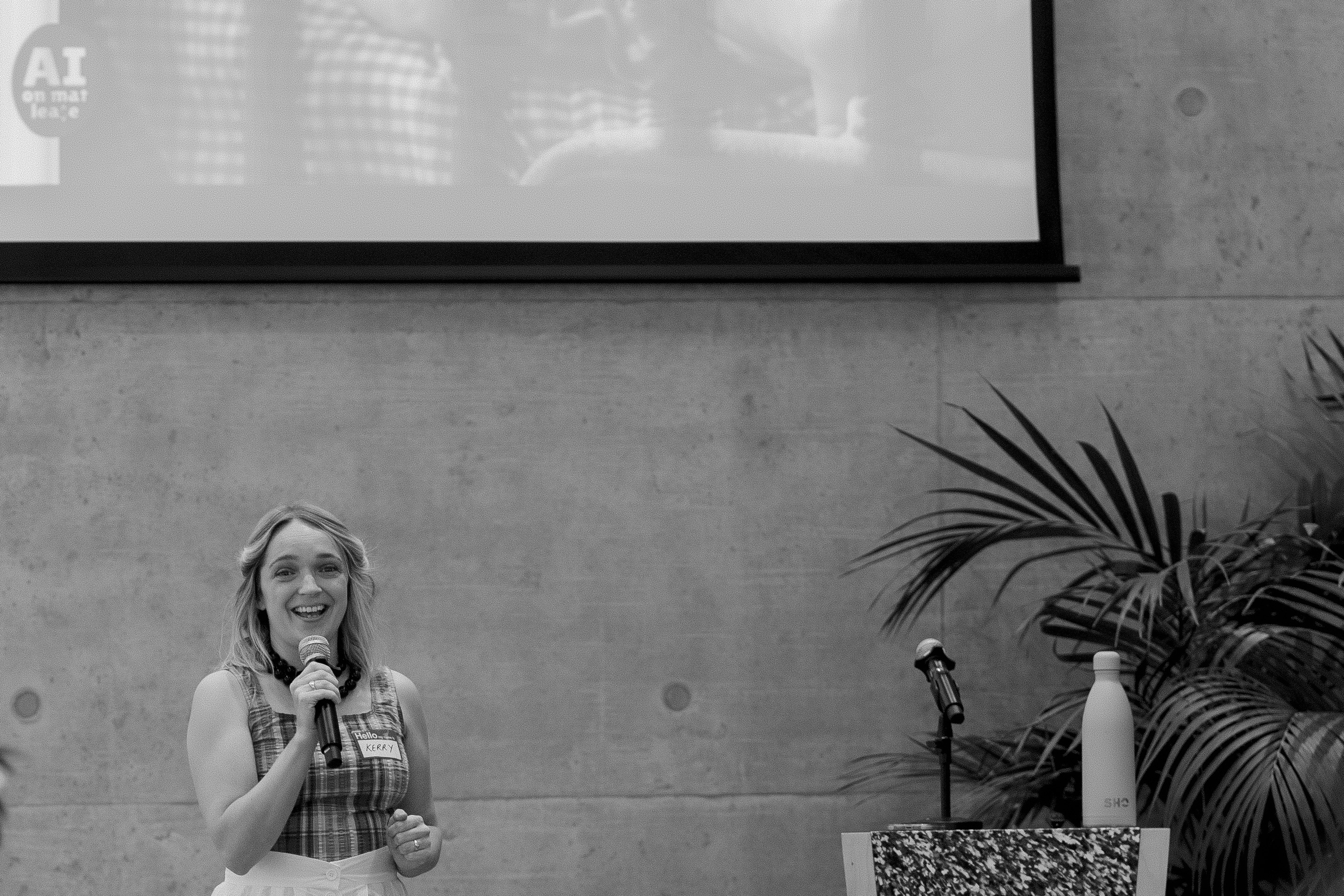 A speaker presenting in the event space at Plus X Innovation